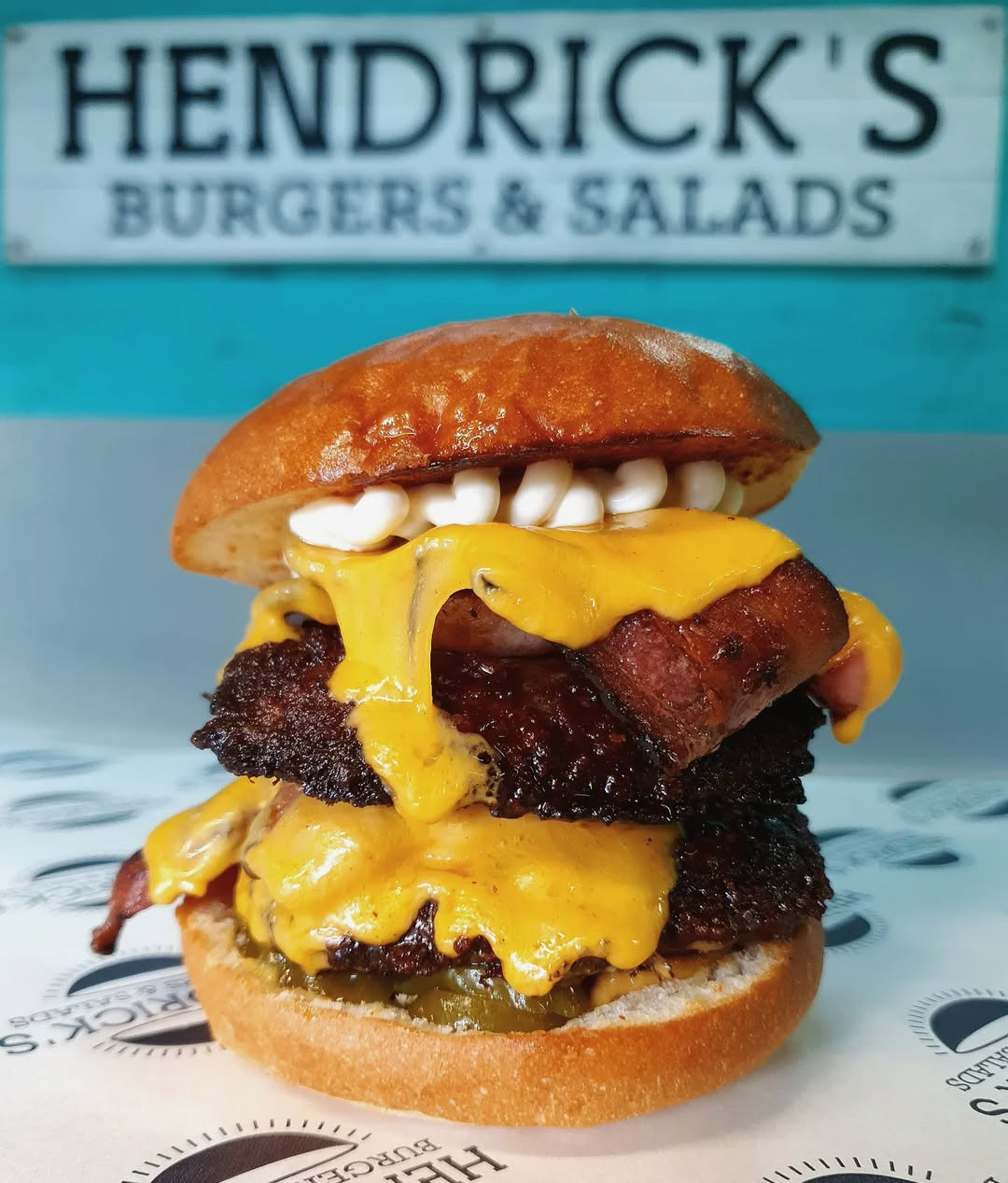 Double patty burger with bacon and melted cheese from Hendrick's